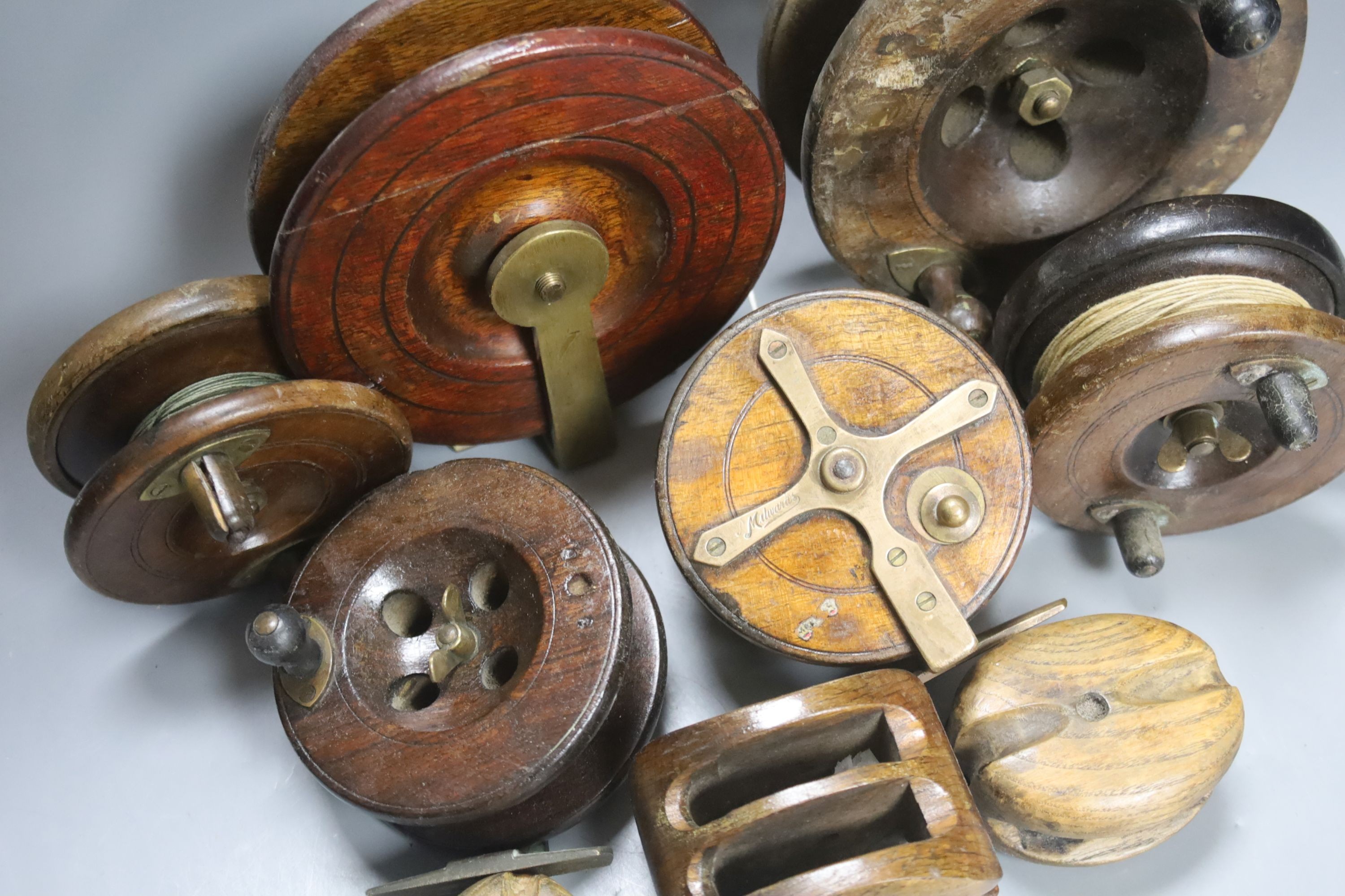 A collection of wooden fishing reels, largest diameter 16cm